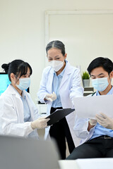 Fototapeta na wymiar A professional Asian senior female doctor training two Asian junior specialist in the lab.