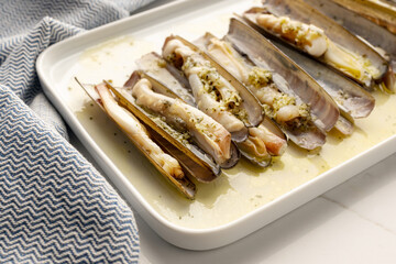 Coked Ensis Clams with garlic and herbs on plate. Typical dish of galician cuisine