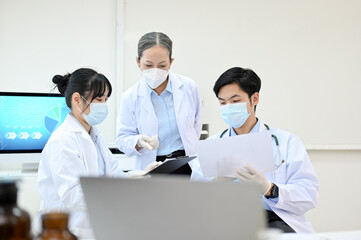 Team of professional Asian scientist in white gown having a medical research meeting in the lab.