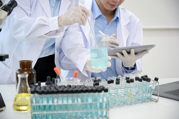 A female scientist adjusts a chemical liquid in the beaker. cropped image