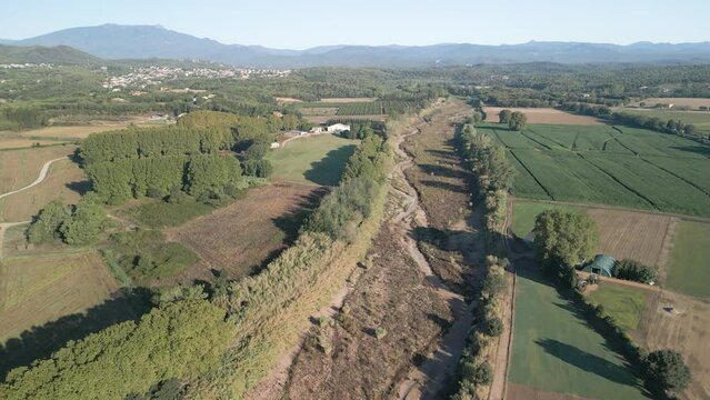 aerial images over a dry river next to crops in spain catalunya