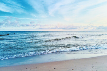 Sand beach with sea waves. Summer vacation and travel concept. Beautiful coastline with blue sea and sand beach
