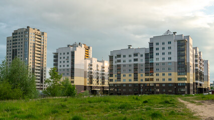 Two beautiful modern multi-storey buildings on the background of gray rainy clouds.   Urban landscape. Residential development.