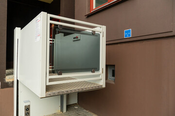 A modern entrance of a residential building equipped with a mechanism for lifting a wheelchair....