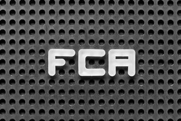 White alphabet letter in word FCA (Abbreviation of free carrier) on black pegboard background