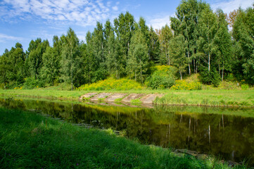 Fototapeta na wymiar Green summer natural landscape with green grass, river and trees. Design background