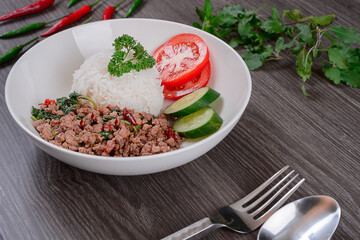 Pork Basil Fried Rice  topped with Stir-fried basil. on wooden table background. top