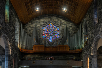 close-up view of the organ and stained glass window in the nave of the Galway Cathedral