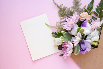 Minimalistic card mockup with  white eustoma flowers. Workspace. Wedding invitation cards, craft envelopes, lisianthus with copy space. Overhead view. Flat lay, top view 