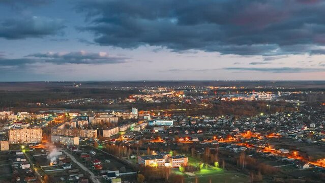 Aerial View Of town Cityscape Skyline In Autumn Evening. Residential District During Sunset. Bird's-eye View. Day To Night Time Lapse Hyperlapse