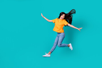 Fototapeta na wymiar Full length photo of impressed brunette lady fly wear orange t-shirt jeans sneakers isolated on teal color background