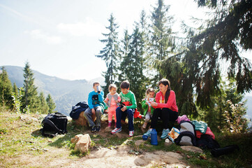 Mother with four kids resting in mountains. Family travel and hiking with childrens.