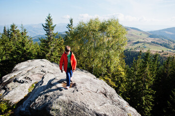 Boy on top of mountain. Children hiking on beautiful day in mountains, resting on rock and admire amazing view peaks. Active family vacation leisure with kids.Outdoor fun and healthy activity.