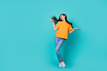 Fototapeta na wymiar Full length photo of lovely brunette lady dance wear t-shirt jeans sneakers isolated on teal color background