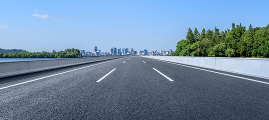 Empty asphalt road and city skyline with modern buildings scenery