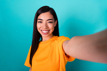 Photo of optimistic brunette long hairstyle lady do selfie wear yellow t-shirt isolated on teal color background