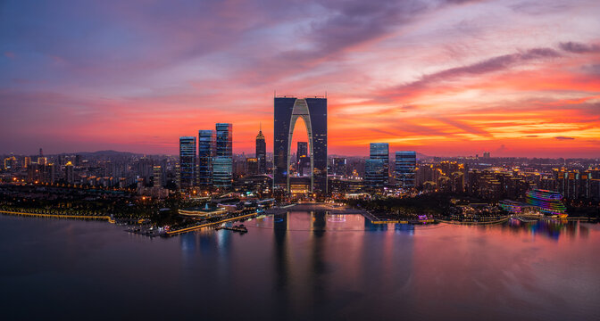 Aerial view of city skyline and modern commercial buildings in Suzhou at sunset, China.