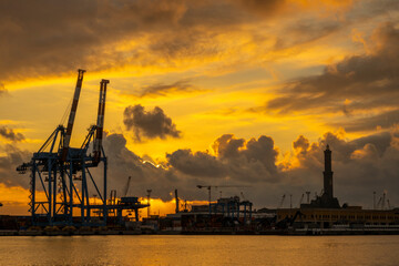 Obraz premium GENOA, ITALY, JANUARY 23, 2022 - View of Lanterna (lighthouse) in the port of the city of Genoa at sunset with cloudy sky, Italy