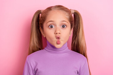 Photo of young adorable cute little girl make hilarious silly faces pout lips isolated on pink...