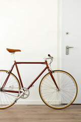 Brown urban bicycle at apartment home, vertical