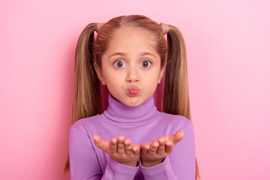 Photo of young lovely sweet little girl daughter send air kiss to her mom isolated on pink color background