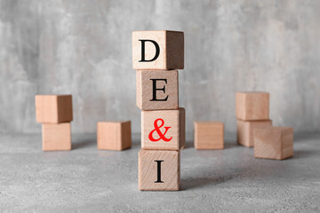 Wooden cubes with abbreviation DE and I (diversity, equity, inclusion) on grunge background