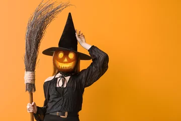 Fototapeten Witch with Halloween pumpkin instead of her head on orange background © Pixel-Shot