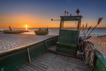 Kuter rybacki - statek, na plaży w Gdyni Orłowo o wschodzie słońca nad morzem bałtyckim z...