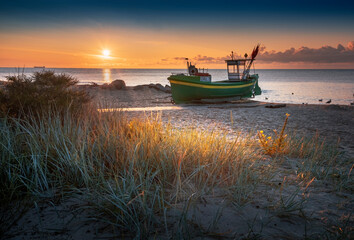 Bateau de pêche - un navire sur la plage de Gdynia Orłowo au lever du soleil sur la mer Baltique avec vue sur la plage
