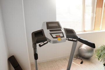 Modern treadmill near window in gym, closeup