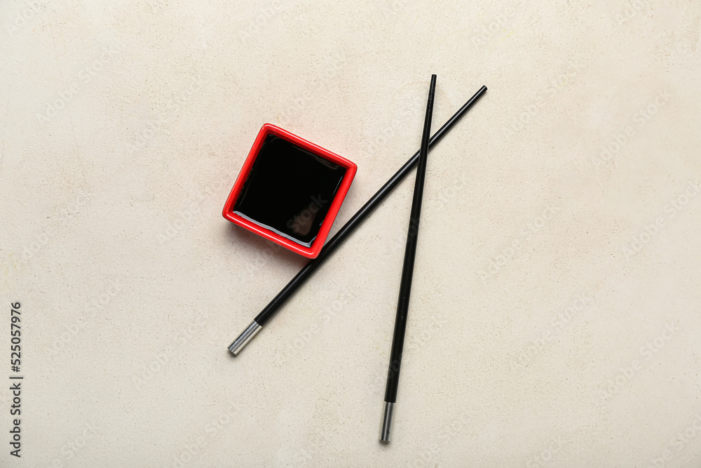 Wall mural red bowl of soy sauce and chopsticks on white background