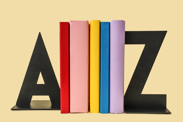 Books with stands in shape of letters on beige background