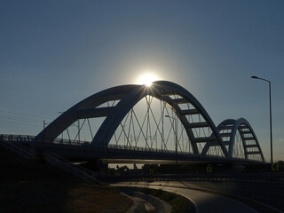 Silhouette of bridge with sun beams over it
