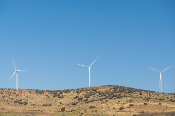 Wind turbine farm power generator in nature landscape.