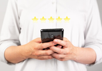 Hands holding phone for giving good feedback. Woman submitting five star assessment. Consumer satisfaction survey. Positive opinion. Goods, service, hotel, application, restaurant rating.