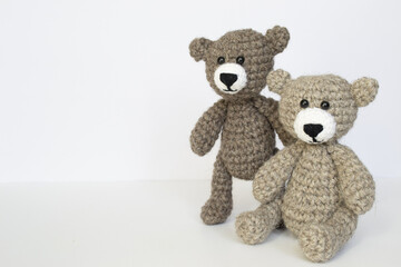 Crocheted gray and brown bears on a white background. Crocheted toy.