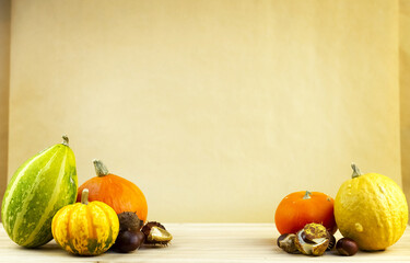 Obraz na płótnie Canvas Decorative pumpkins with chestnuts on a wooden board