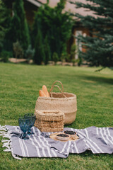 Beautiful romantic picnic with cake and two glasses of wine on the green meadow.