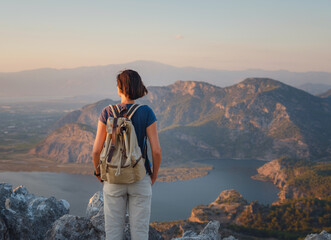 Travel to Turkey, viewpoint over Dalyan Iztuzu Beach. . Smiling woman taking break on hiking trip looking at view at sunset. Explore natural wonders of Turkey