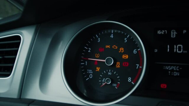 Close up of sleek car dashboard of transportation vehicle lights turn on after ignition. Oil change, error signs, epc and abs, parking brake initiate, leftover mileage and rpm