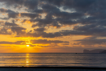Dark clouds over Alghero shore at sunset