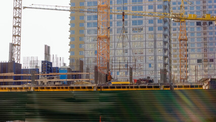 Fototapeta premium Crane lifts up metal frame on the construction site. Big construction.