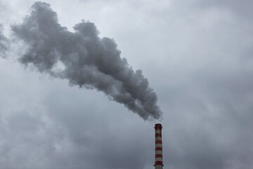 Top of the coal power plant chimney with white smoke, toxic emissions, rising in the sky, low angle shot. Air and environmental pollution concept.