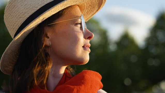 Attractive young woman with red scarf looking at the sun