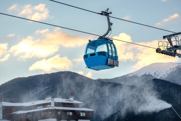 Bansko, Bulgaria winter resort with ski lift gondola cabins, and sunset mountains view