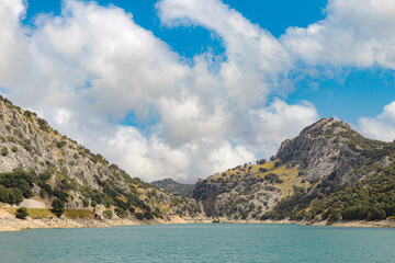 gor blau reservoir between the mountains of mallorca with a sky with clouds