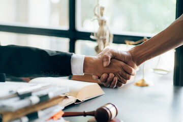 Obraz premium Businessman shaking hands to seal a deal with his partner lawyers or attorneys discussing a contract agreement.Legal law, advice, and justice concept