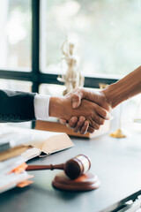 Businessman shaking hands to seal a deal with his partner lawyers or attorneys discussing a contract agreement.Legal law, advice, and justice concept - obrazy, fototapety, plakaty