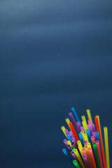 Obraz premium Colorful plastic drinking straws, close up as background. colored tubules for juice and cocktails on black wooden table