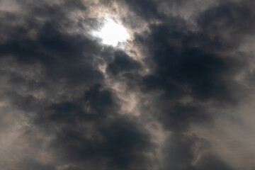 Obraz premium defocused the dark cloudy sky with gaps shining from the sun's light in the middle